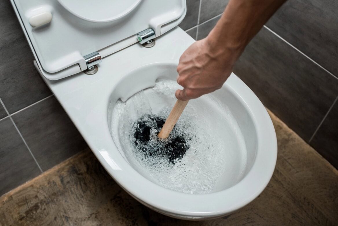 Clogged toilet plumber and plunger to unblock
